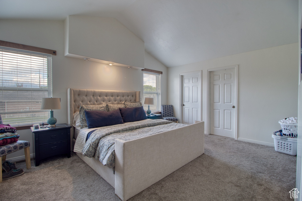 Bedroom featuring vaulted ceiling and light colored carpet