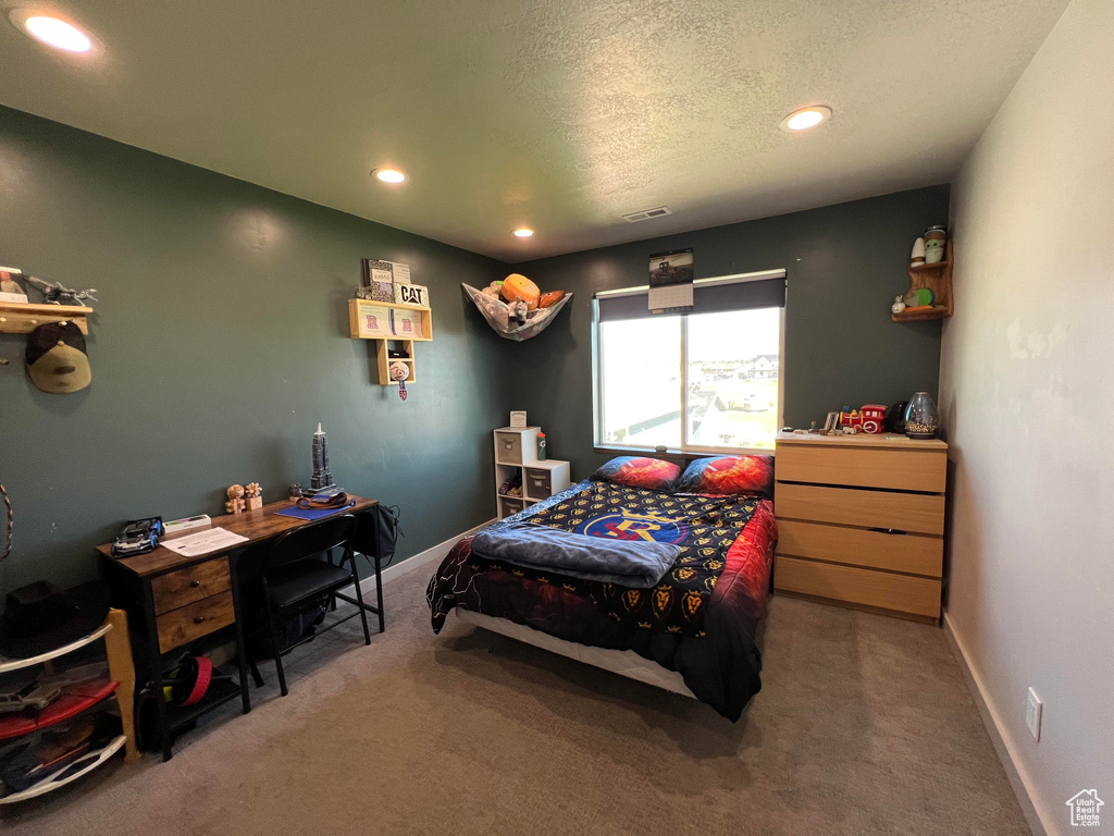 Carpeted bedroom featuring a textured ceiling