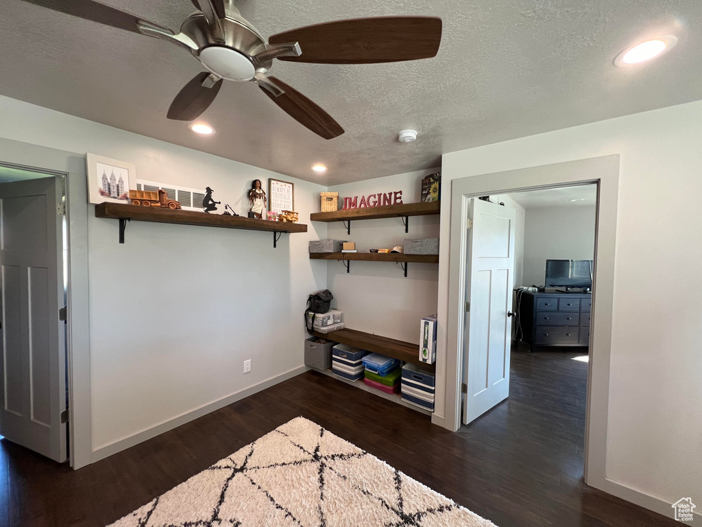 Interior space with a closet, dark hardwood / wood-style flooring, ceiling fan, and a textured ceiling