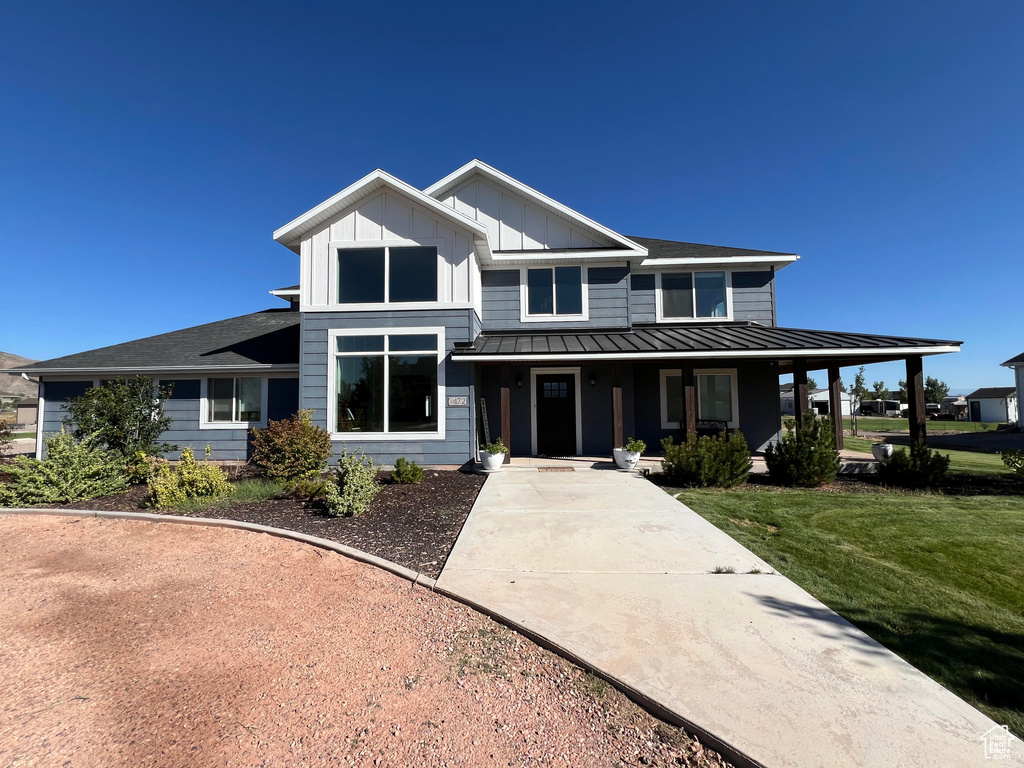 View of front of house featuring covered porch and a front lawn