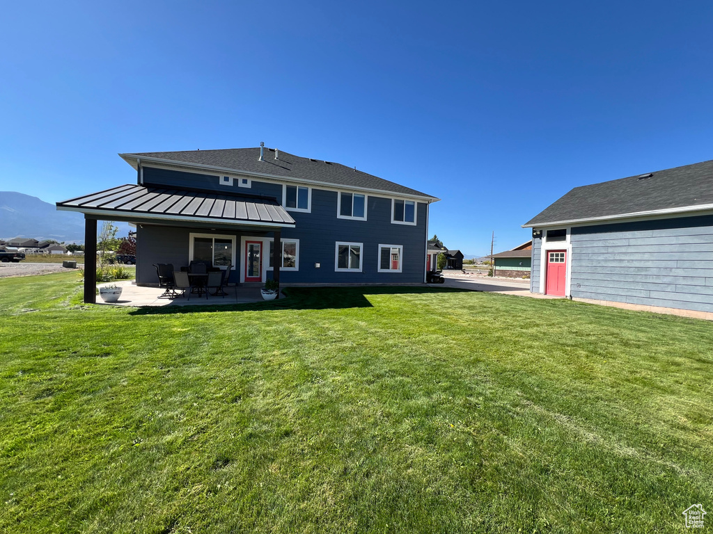 Rear view of property featuring a yard and a patio area