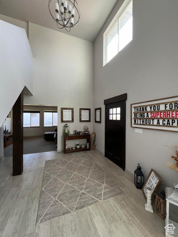 Entryway featuring hardwood / wood-style floors, high vaulted ceiling, and a healthy amount of sunlight