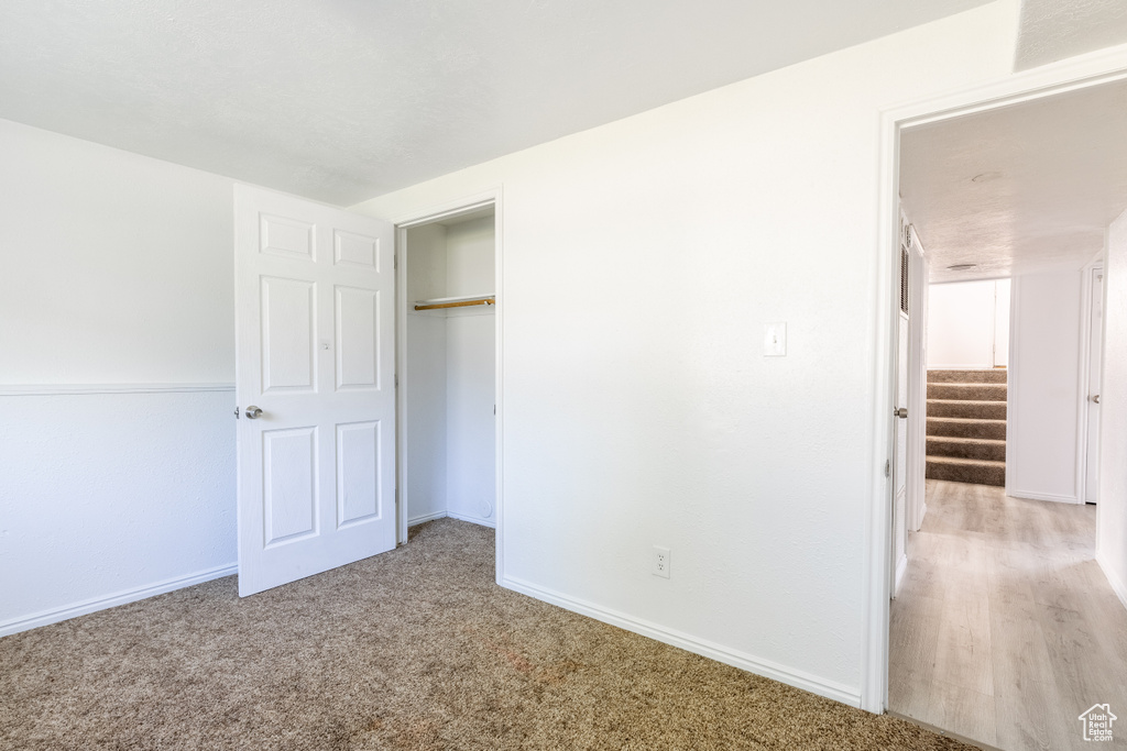 Unfurnished bedroom with a closet and carpet floors