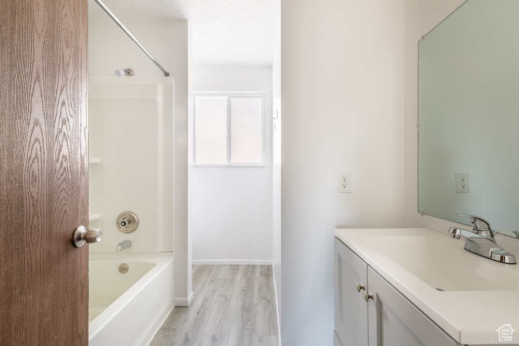 Bathroom featuring bathtub / shower combination, hardwood / wood-style flooring, and vanity