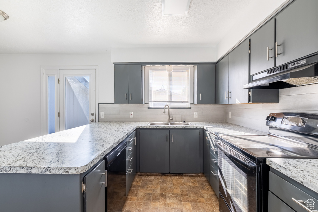 Kitchen featuring black appliances, backsplash, sink, and gray cabinetry