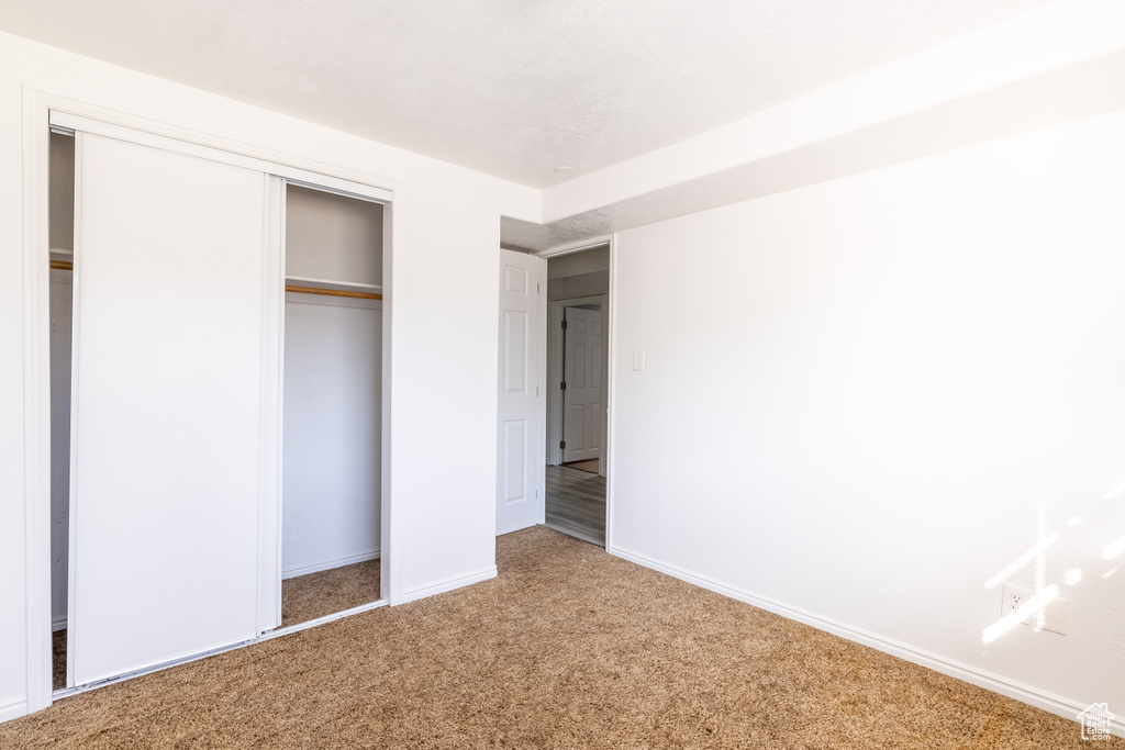 Unfurnished bedroom featuring a closet and carpet