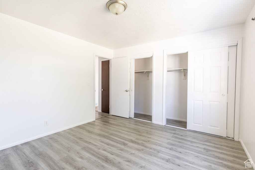 Unfurnished bedroom featuring a textured ceiling and light hardwood / wood-style floors