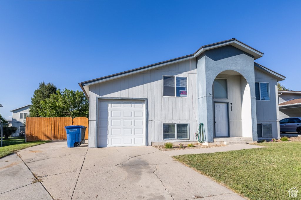 View of front of property with a front yard and a garage