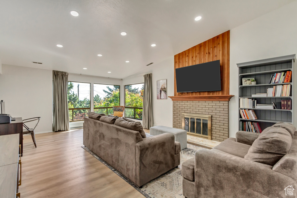 Living room featuring light hardwood / wood-style floors and a brick fireplace