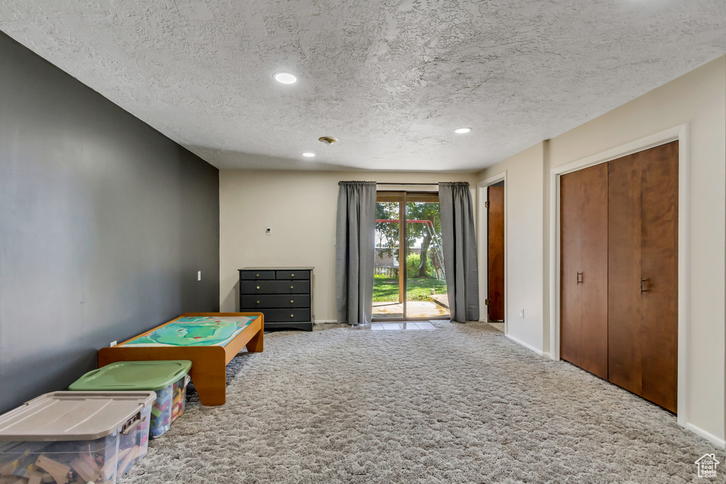 Playroom featuring a textured ceiling and carpet