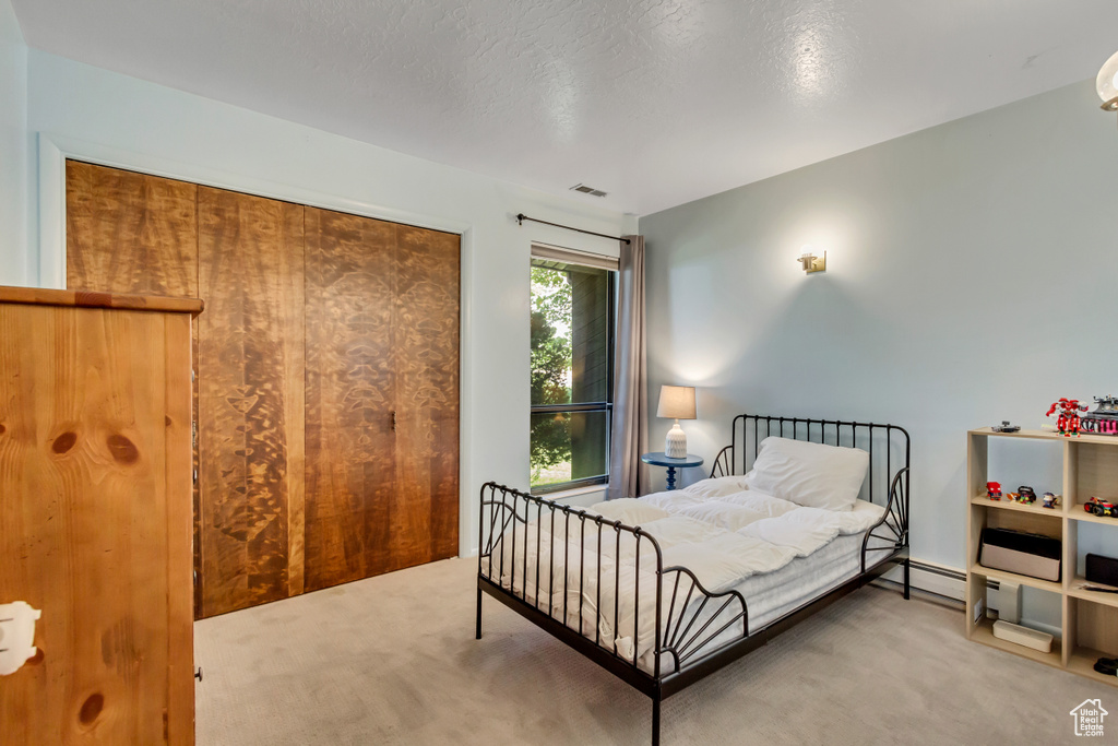 Bedroom with a textured ceiling and carpet floors