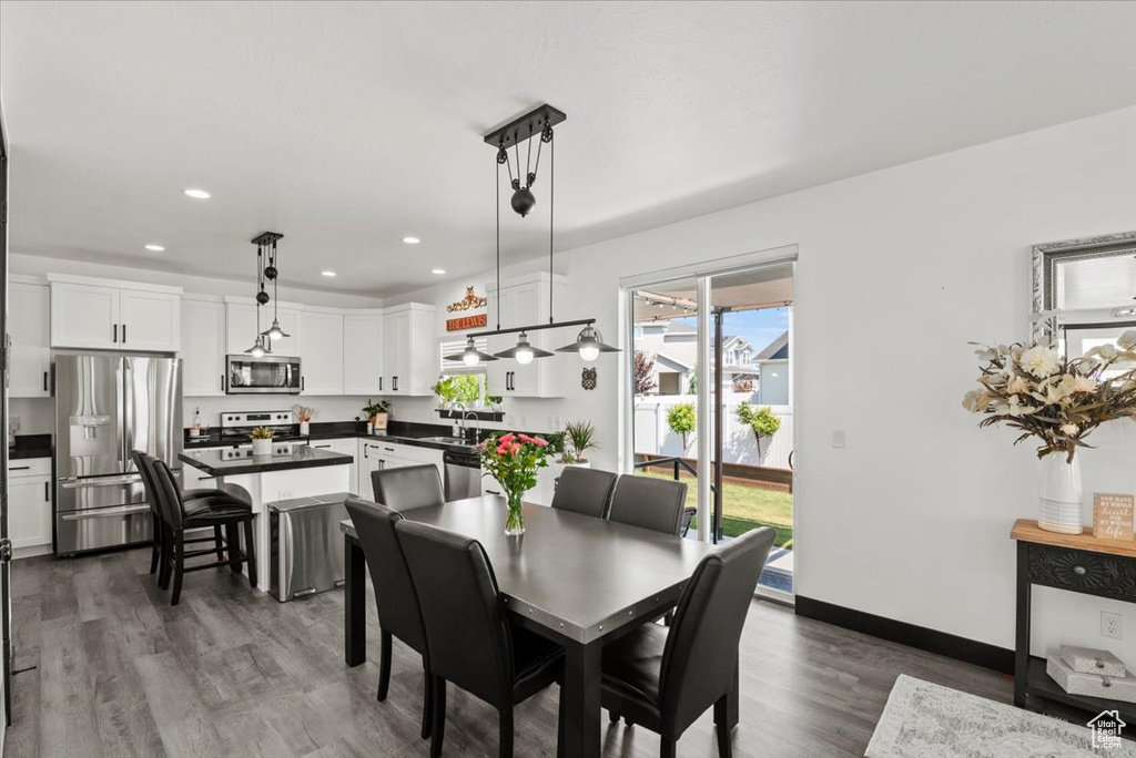 Dining room with a healthy amount of sunlight, sink, and dark hardwood / wood-style flooring