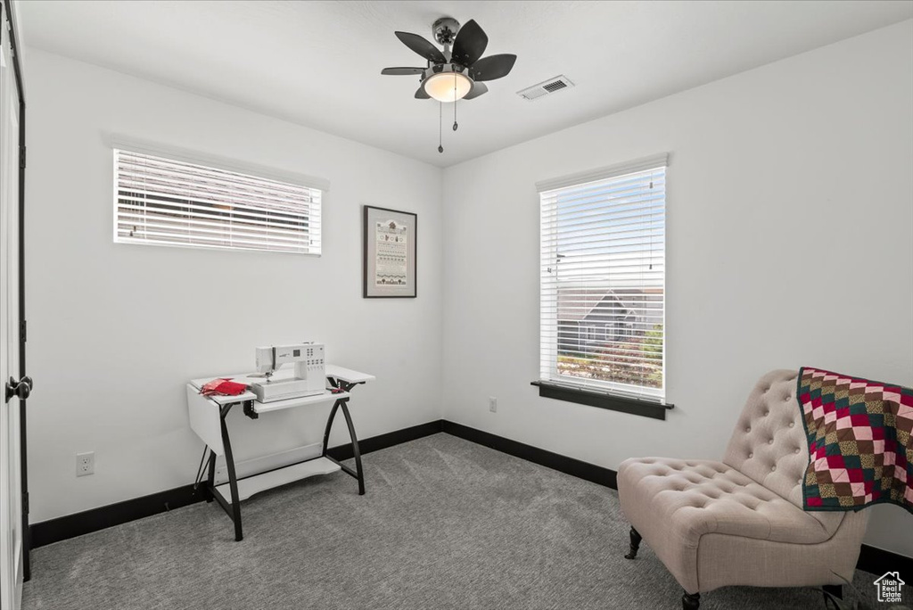 Living area featuring ceiling fan and light carpet