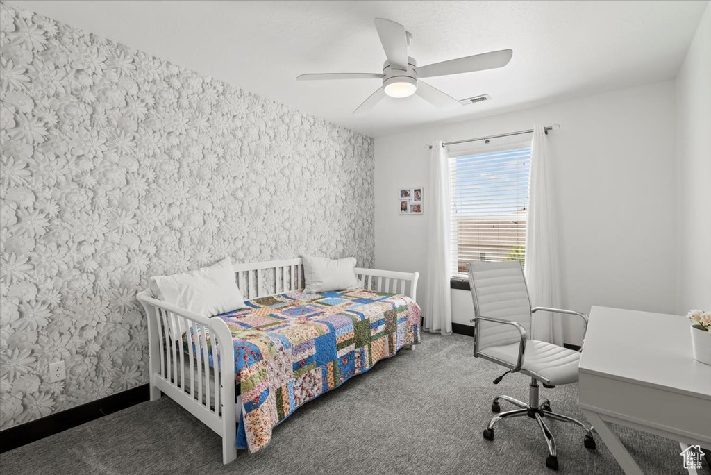 Carpeted bedroom featuring ceiling fan