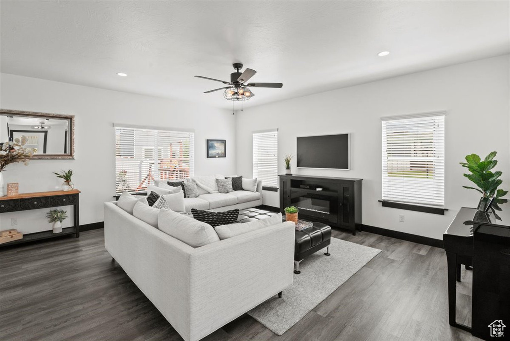 Living room with ceiling fan and dark hardwood / wood-style floors