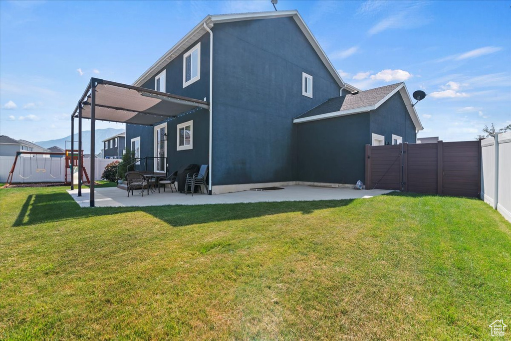 Back of property featuring a lawn and a patio