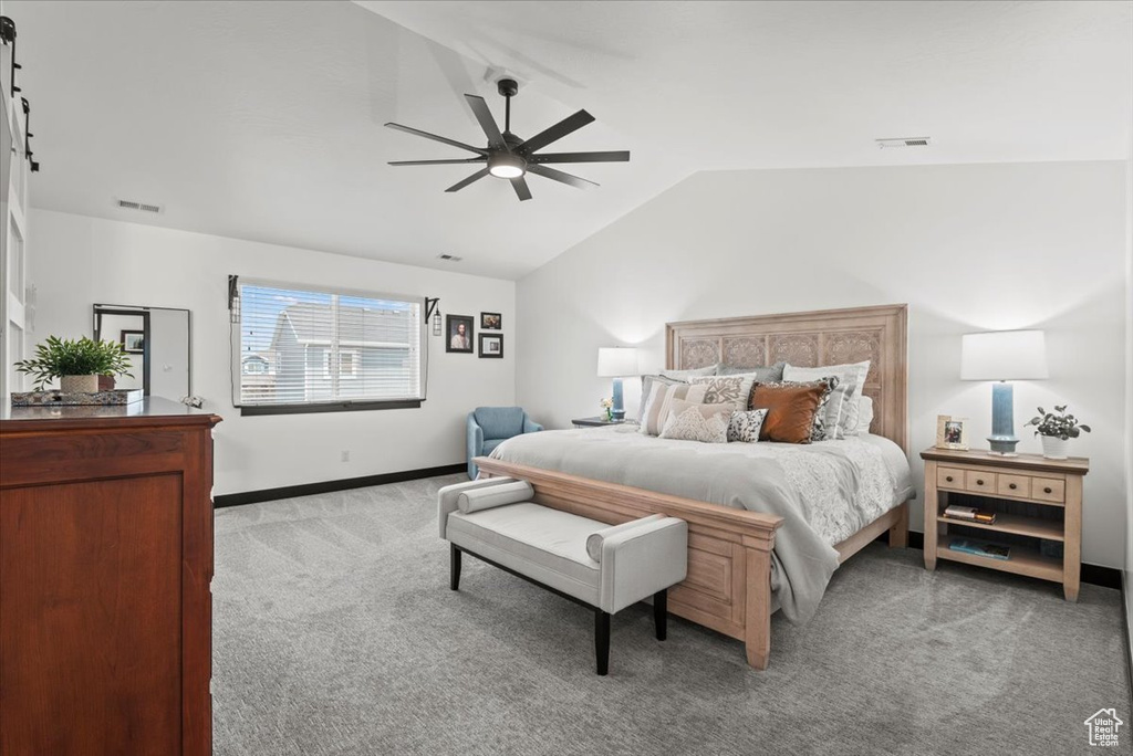 Carpeted bedroom with lofted ceiling and ceiling fan