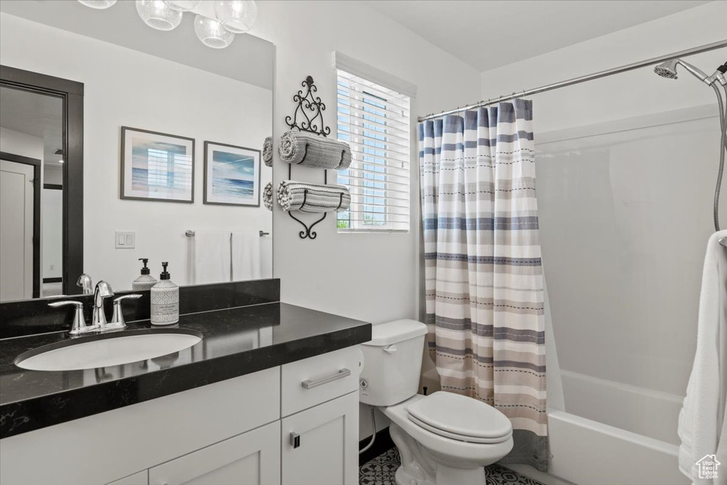 Full bathroom featuring vanity, toilet, and shower / tub combo with curtain