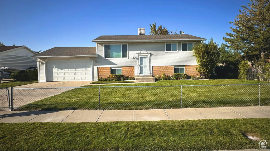 Bi-level home with a front lawn and a garage