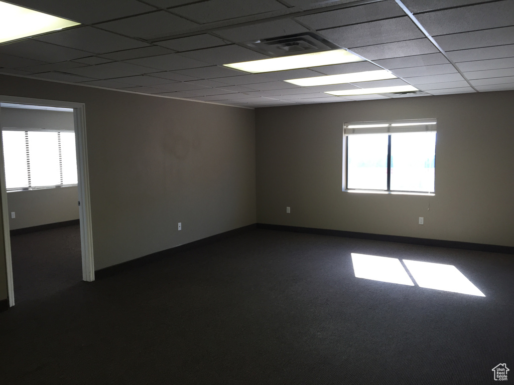 Empty room with a wealth of natural light and a paneled ceiling