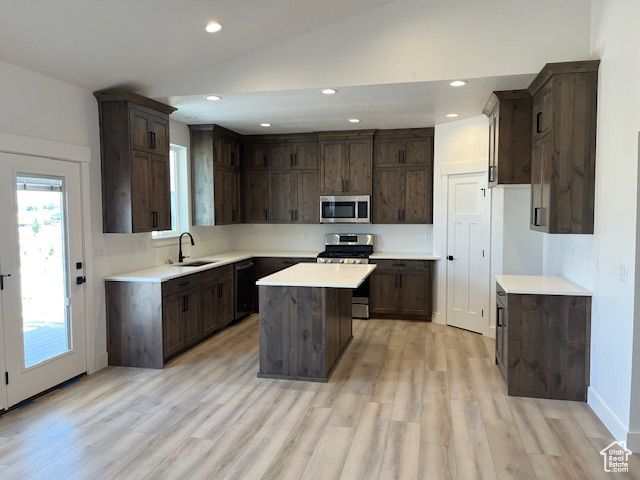 Kitchen featuring plenty of natural light, stainless steel appliances, sink, and a center island