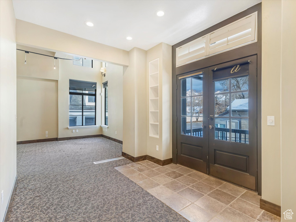 Entrance foyer featuring carpet and french doors