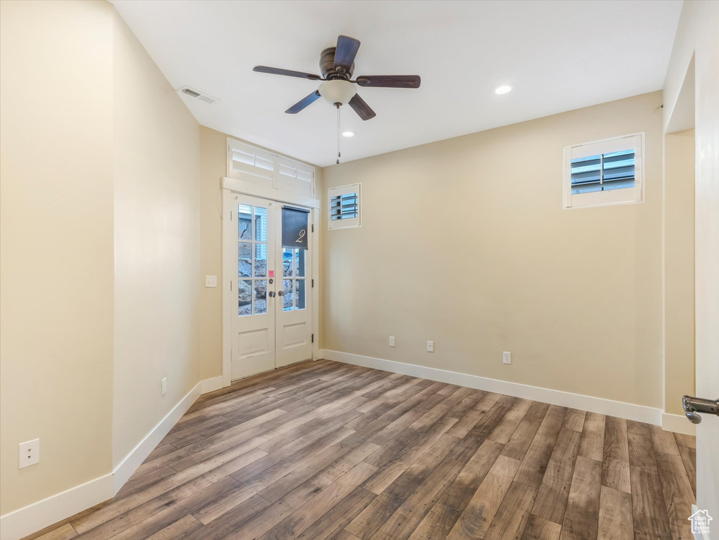 Spare room with hardwood / wood-style flooring, ceiling fan, and french doors