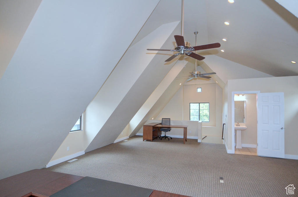 Additional living space featuring lofted ceiling, ceiling fan, light colored carpet, and sink