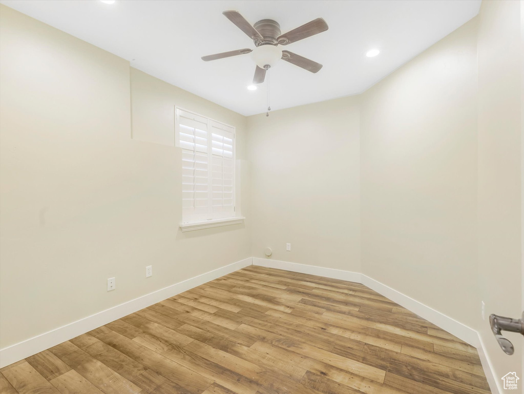 Empty room with ceiling fan and light hardwood / wood-style flooring