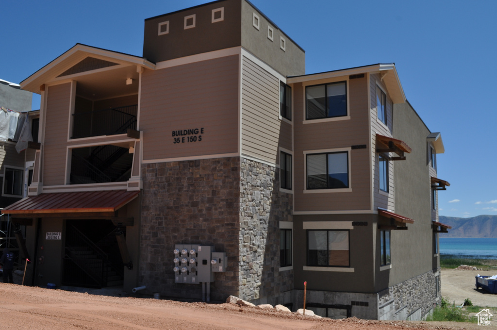 View of building exterior featuring a water and mountain view