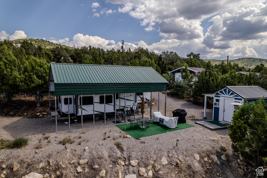Rear view of property with a patio, an outdoor structure, and a mountain view