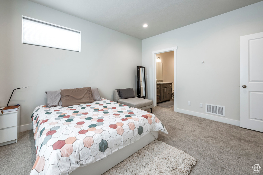 Bedroom with light carpet, baseboards, recessed lighting, and ensuite bathroom
