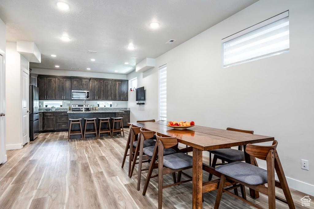 Dining area with light wood-style floors, recessed lighting, and baseboards