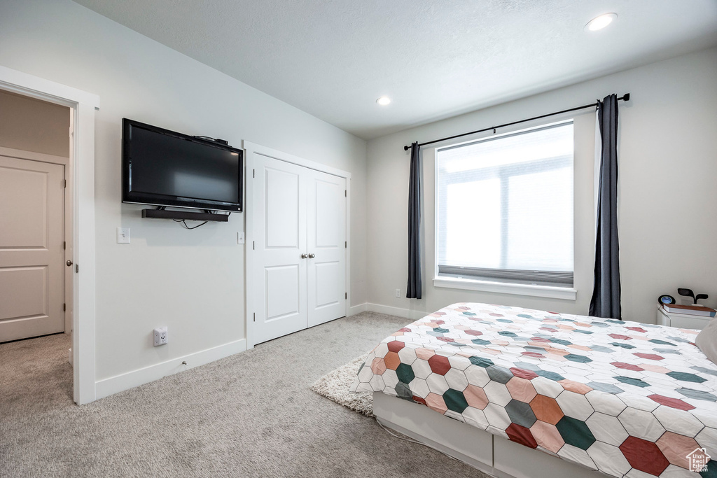 Bedroom featuring light carpet