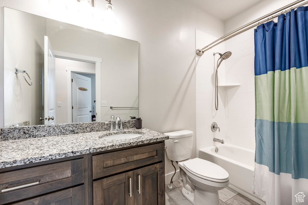 Full bathroom with vanity, shower / tub combo, and toilet