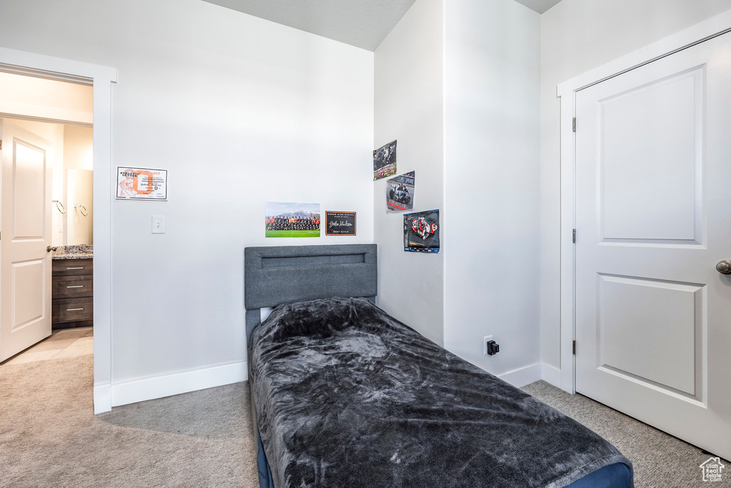Bedroom with light carpet and baseboards