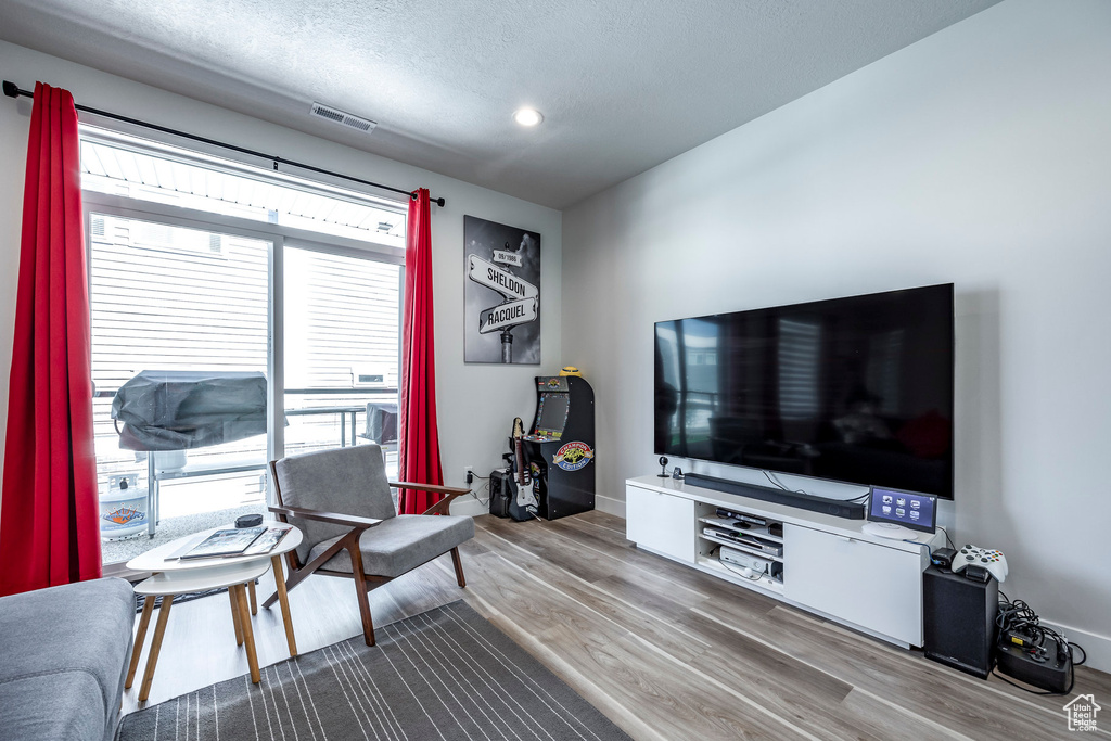 Living room featuring a textured ceiling, a healthy amount of sunlight, and hardwood / wood-style floors