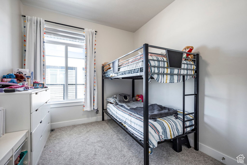 Bedroom featuring light colored carpet, multiple windows, and baseboards