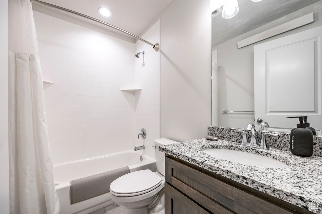 Full bathroom with toilet, shower / tub combo with curtain, and vanity