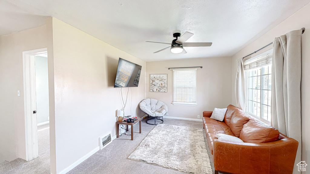 Sitting room featuring light colored carpet and ceiling fan