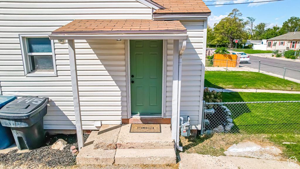 View of exterior entry featuring a lawn