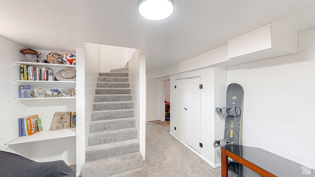 Hallway featuring light colored carpet