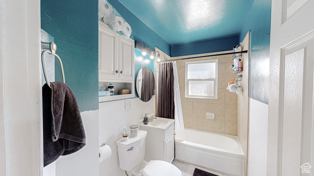 Full bathroom featuring vanity, toilet, and shower / bath combination with curtain