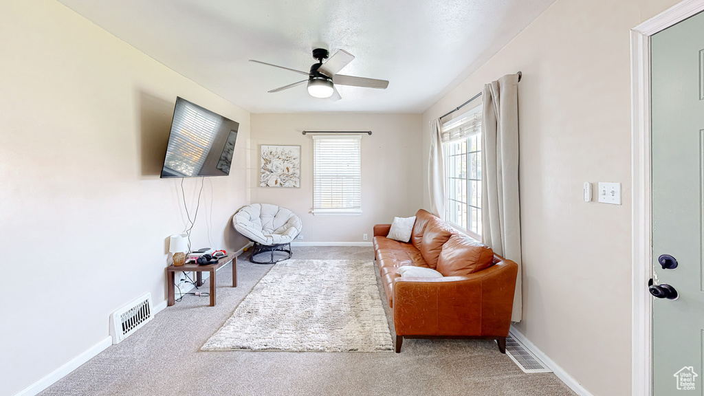 Sitting room featuring light colored carpet and ceiling fan