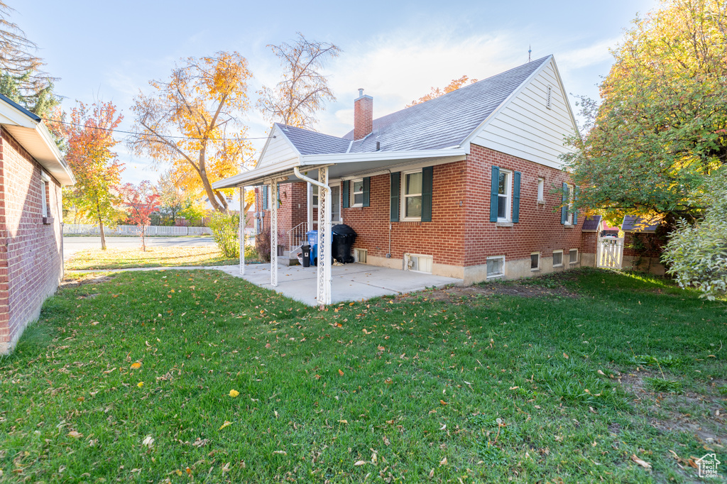 Back of property with a lawn and a patio area