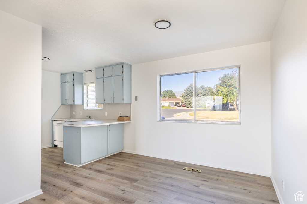 Kitchen featuring a kitchen breakfast bar, kitchen peninsula, sink, and light hardwood / wood-style flooring