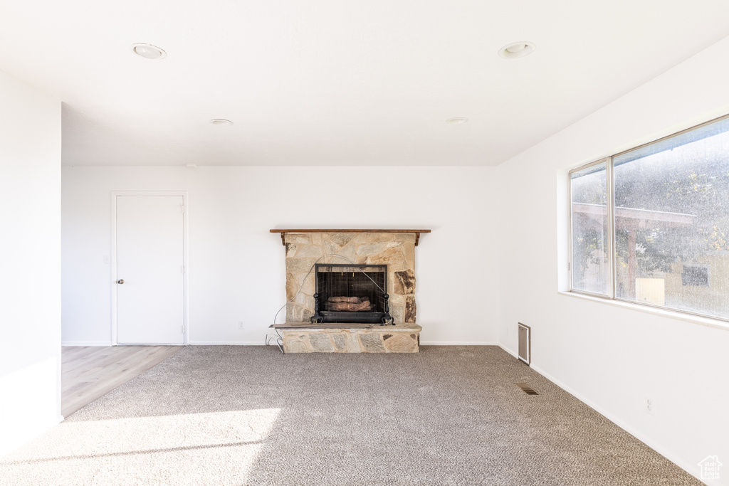 Unfurnished living room with carpet floors and a fireplace