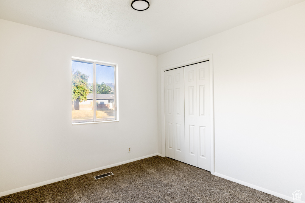 Unfurnished bedroom with carpet and a closet