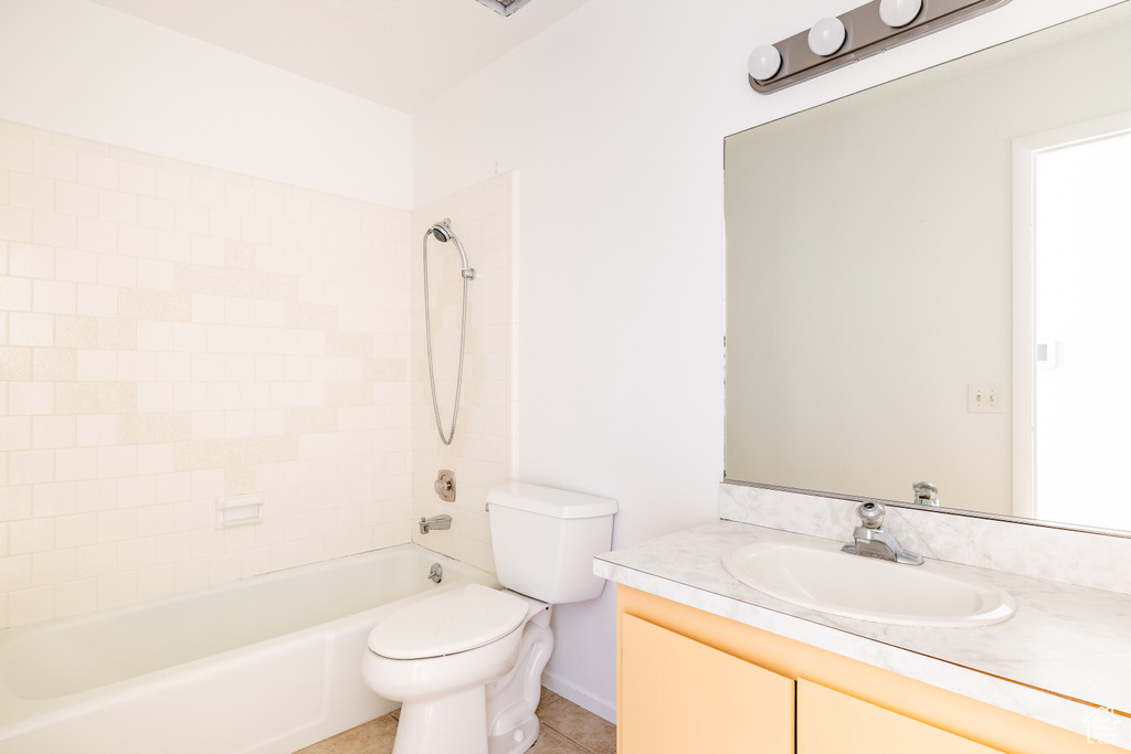 Full bathroom featuring vanity, toilet, tile patterned floors, and tiled shower / bath