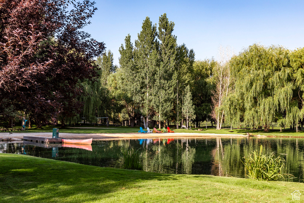 View of community featuring a lawn and a water view